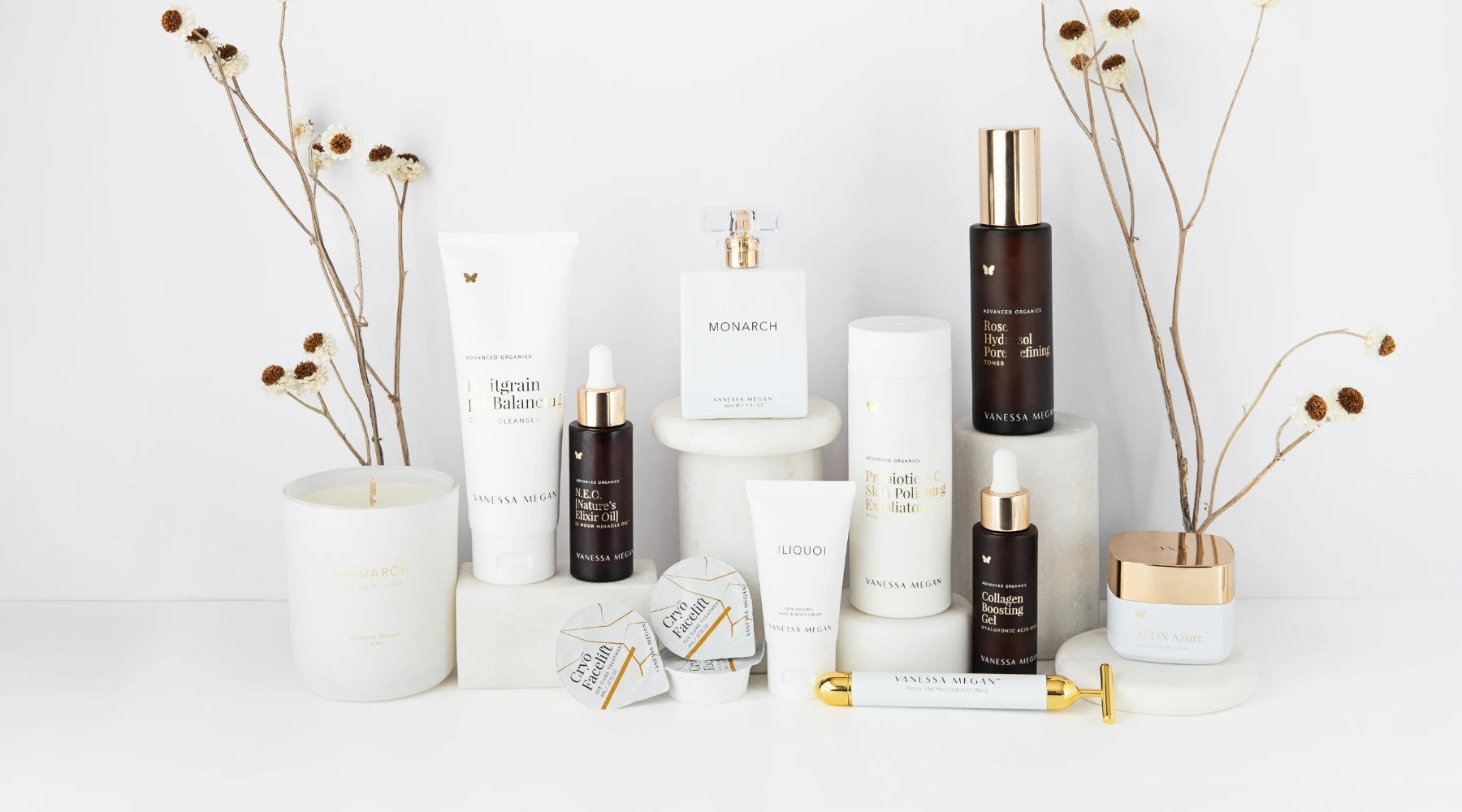 Vanessa Megan luxury organic skincare collection displayed elegantly on a white surface with dried floral accents. Featuring award-winning, 100% natural and scientifically proven skincare products for radiant, healthy skin